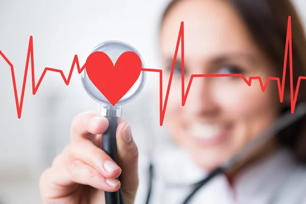 Doctor with phonendoscope at background, heart and cardiogram in front. Concept of medical help. — Stock Photo, Image