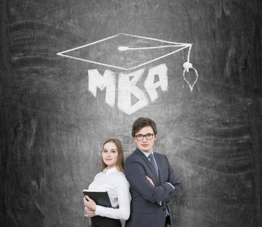 Businessman and businesswoman shoulder to shoulder, MBA and academic hat drawn over them. Black background. Concept of education.