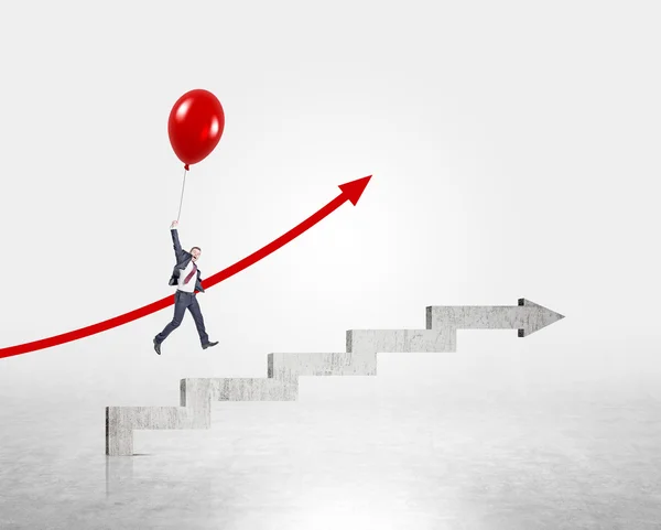 Geschäftsmann fliegt mit rotem Luftballon über von Betonpfeil geformte Treppen. Konkreter Hintergrund. Konzept des Karrierewachstums. — Stockfoto