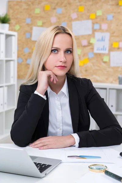 Businesswoman with head on hand in front of computer. Office at background. Concept of work. — Stock Photo, Image