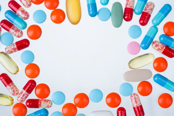 Muchas píldoras de color de diferentes tamaños, círculo en blanco en el medio. Concepto de medicina. Prepárate. . —  Fotos de Stock