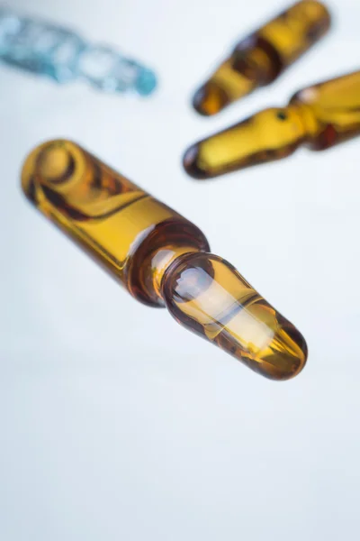 Ampolla amarilla, otras ampollas en el fondo, de cerca. Concepto de medicina . —  Fotos de Stock