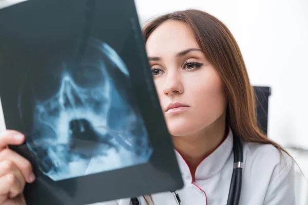 Female doctor looking at X-rays. White background. Concept of work. — Stock Photo, Image