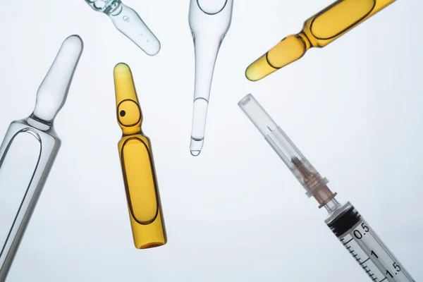 Many ampoules of different types and colours and syringe. Concept of injection. — Stock Photo, Image