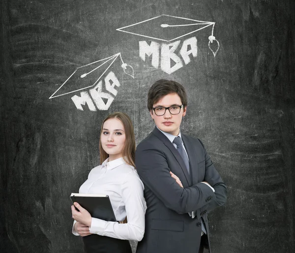 Mężczyzna i kobieta kaukaski studenci z abstrakcyjne czapki MBA sporządzone na tablicy — Zdjęcie stockowe