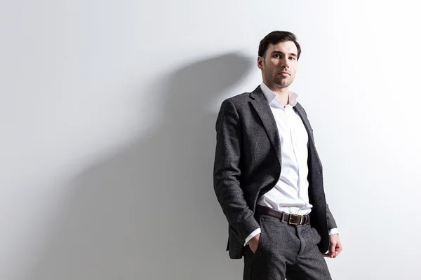 Man in black suit against white wall. Mock up — Stock Photo, Image