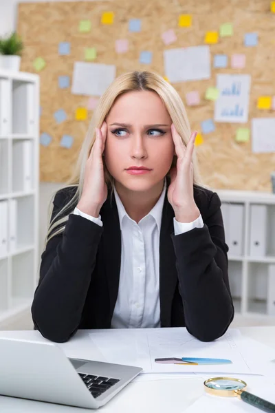 Betonade affärskvinna sitter vid skrivbord i office — Stockfoto