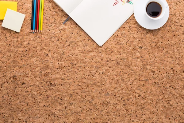 Cork tabell, notebook, kaffe, papper och pennor på den. Ovanifrån. Begreppet arbete. — Stockfoto