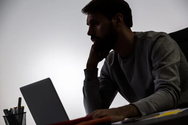 Silhouette d'homme d'affaires travaillant sur ordinateur portable au bureau — Photo