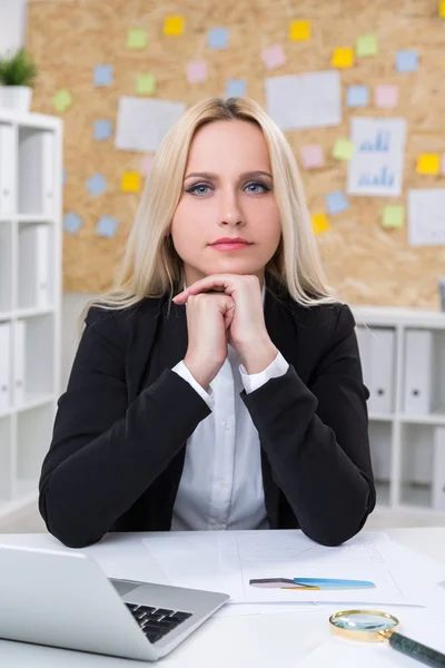 Серйозна бізнес-леді сидить за столом в офісі — стокове фото