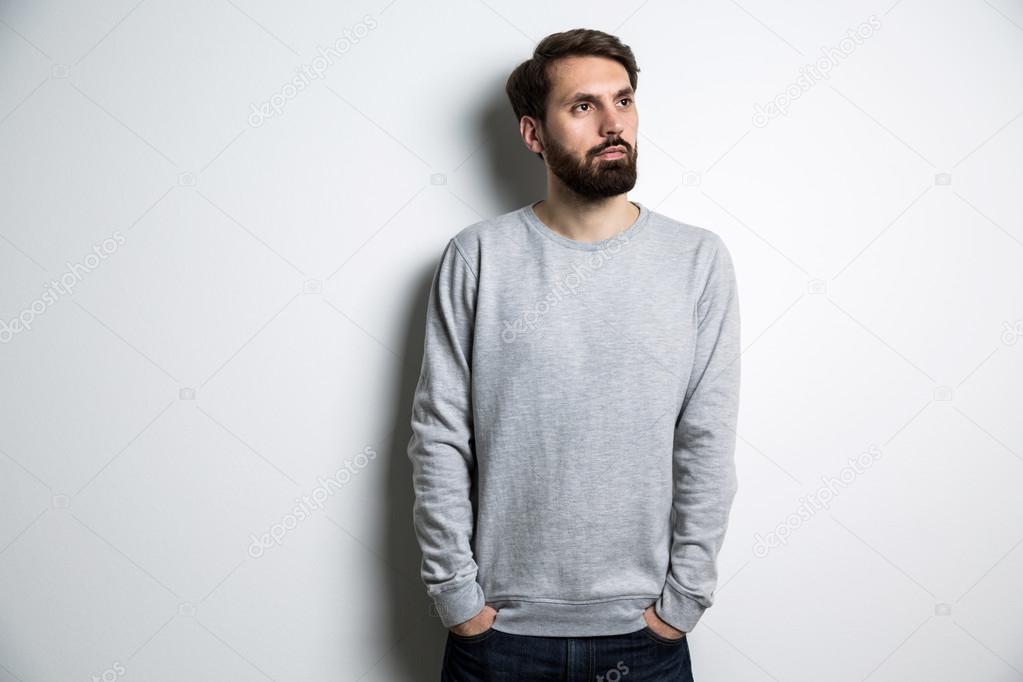 Young male in long sleeved sweatshirt on light grey background. Mock up