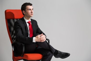 Çapraz ayaklı oturan erkek