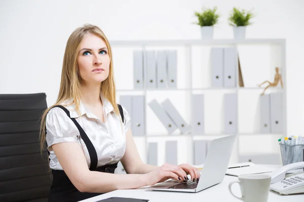 Thoughtful businesswoman typing — Stock Photo, Image