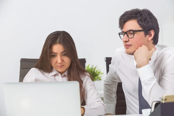 Två företagare titta på laptop skärmen i office — Stockfoto