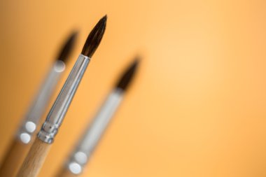 Üç fırçalar turuncu arka plan