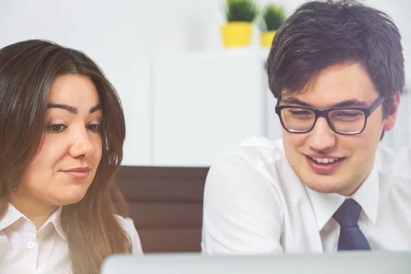 Atractivos empresarios sonriendo y discutiendo algo en la oficina —  Fotos de Stock