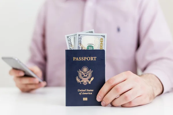 Homem com passaporte usando telefone — Fotografia de Stock