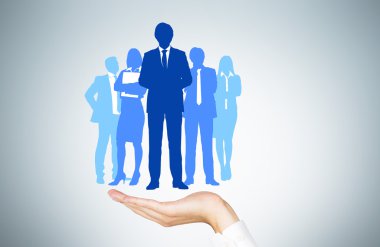 Human resources concept with man's hand holding businesspeople silhouettes clipart