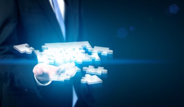 puzzle parçaları tutan işadamı