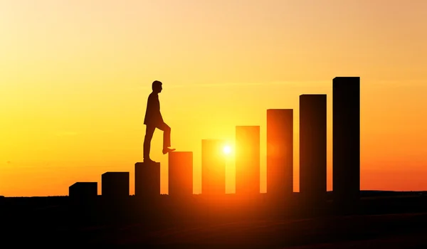 Businessman climbing chart bars — Stock Photo, Image