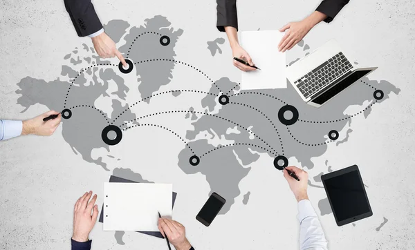 Concepto de networking global con equipo de empresarios trabajando en superficie de hormigón con mapa, red y dispositivos electrónicos —  Fotos de Stock