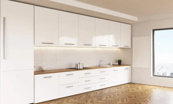 Вид сбоку на роскошный кухонный интерьер с белой мебелью, деревянным полом, отбеливателем и окном с видом на город. 3D рендеринг — стоковое фото