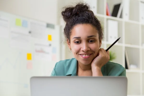Sorridente ragazza nera utilizzando il computer portatile — Foto Stock