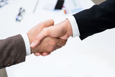 Yukarıda office masaüstü bulanık öğeleri ile el sıkışan iş adamları Üstten Görünüm