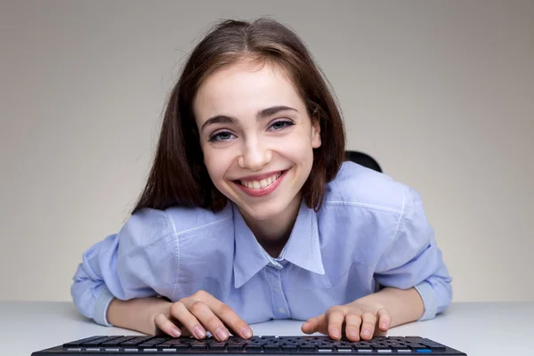 Atractiva hembra sonriente usando el teclado — Foto de Stock