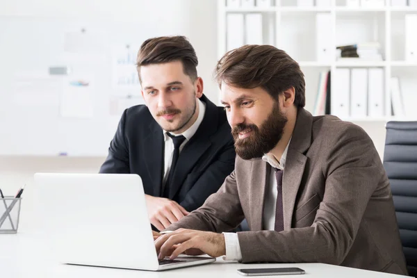 Empresarios discutiendo proyecto en portátil — Foto de Stock