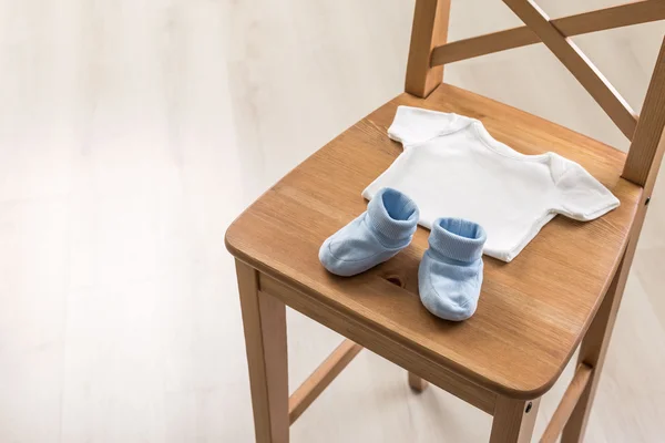 Cadeira com roupas de bebê — Fotografia de Stock