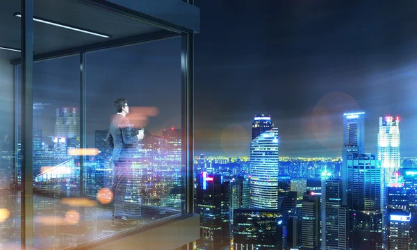 Бізнесмен на панорамному балконі вночі — стокове фото