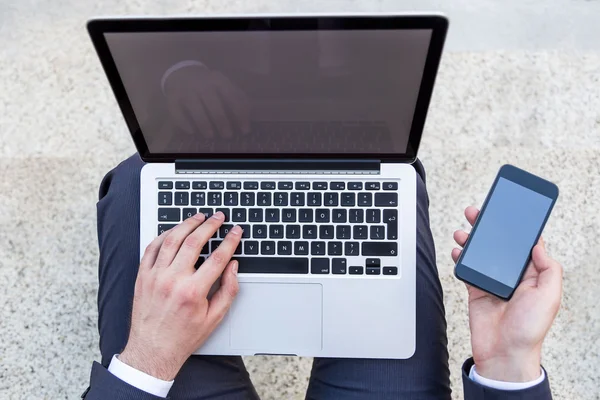 Uomo d'affari con laptop e telefono — Foto Stock