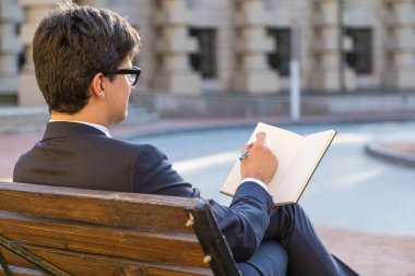 İşadamı not defterine yazıyor.