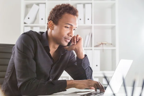 Homem no telefone usando notebook — Fotografia de Stock