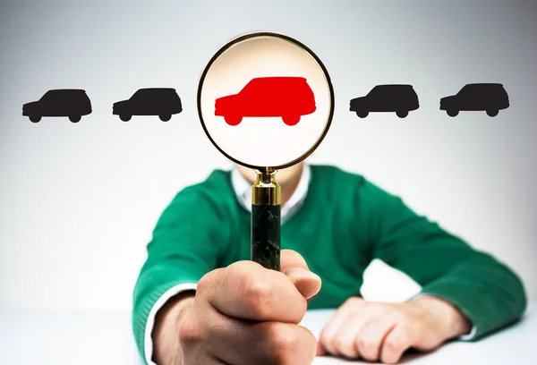 Magnifier with red car icon instead of man's head on light background with black car icons. Concept of choice — Stock Photo, Image