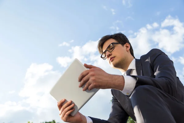 Atractivo hombre de negocios utilizando tableta fuera — Foto de Stock