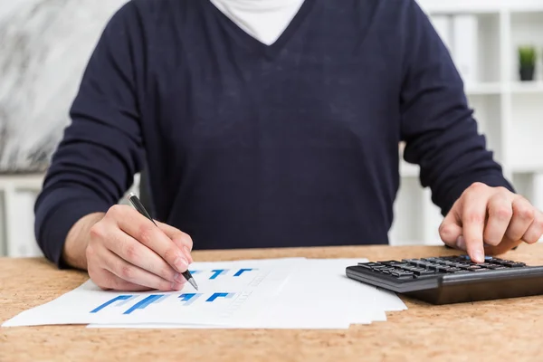 Vista frontal do contador trabalhando na mesa de cortiça com calculadora e relatório de negócios — Fotografia de Stock