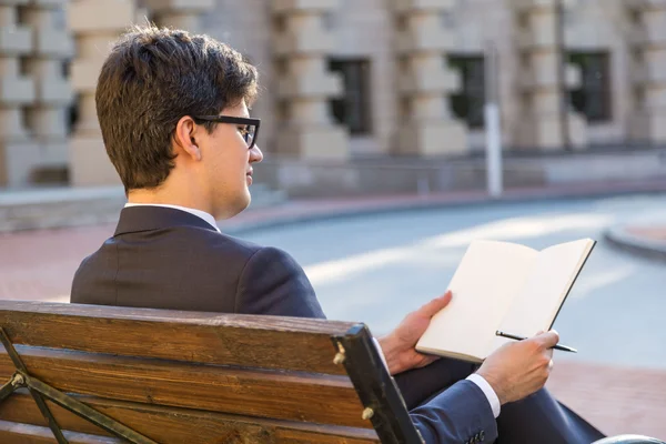 Young businessman writing in notepad