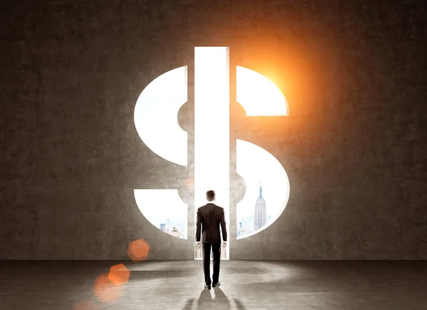 Businessman in front of wall with dollar sign — Stock Photo, Image