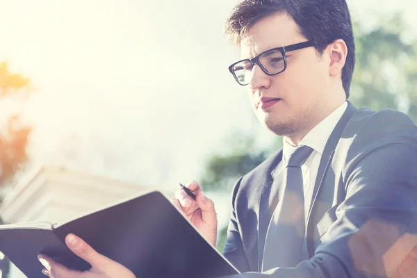 Empresario escribiendo en bloc de notas — Foto de Stock