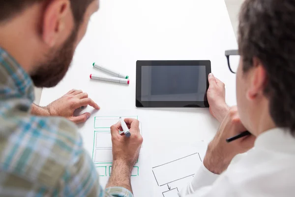 Δύο άνδρες που κοιτάζουν την οθόνη του tablet σκέψης σε προκλητική επιχειρηματικό πρόβλημα. Έννοια της ανταλλαγής ιδεών — Φωτογραφία Αρχείου