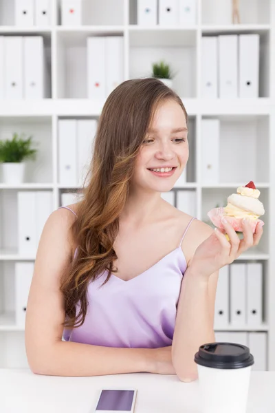 Chica mirando cupcake — Foto de Stock