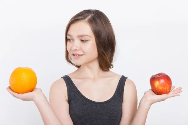 Chica con naranja y manzana —  Fotos de Stock