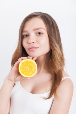 Elinde yarım portakal ciddi kızla. Düşünce kavramı. Organik fitness
