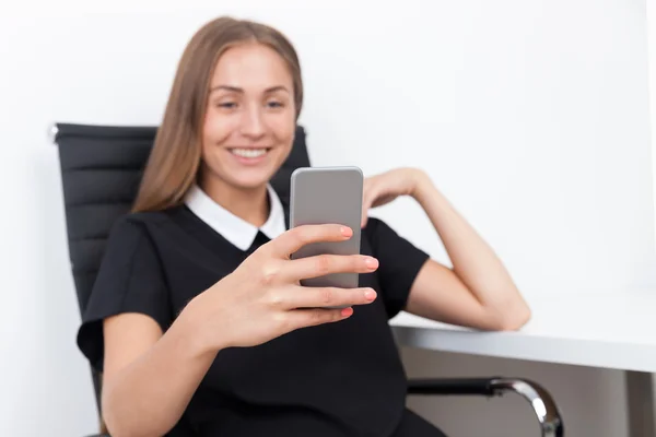 Businesswoman surfing net on her phone — Stock Photo, Image
