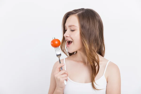 Girl biting tomato — Stock Photo, Image