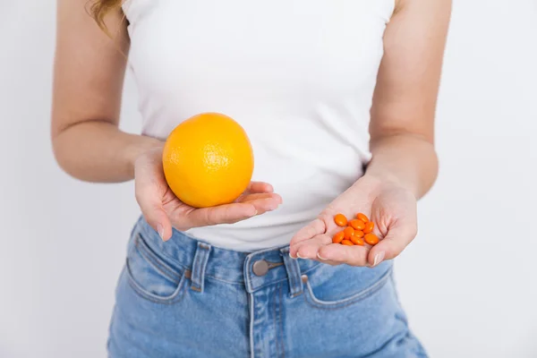 Chica con naranja y pastillas —  Fotos de Stock