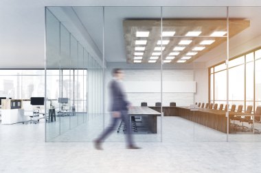 Takım elbiseli adam konferans salonuna gidiyor.