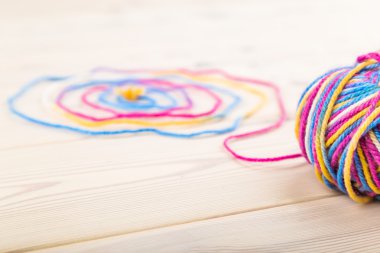 Yün büyük paket spiral kıvrık onun iplik ile ahşap masanın üstüne yalan. Hobi ve serbest zaman kavramı. Yakın çekim. Üstten Görünüm.